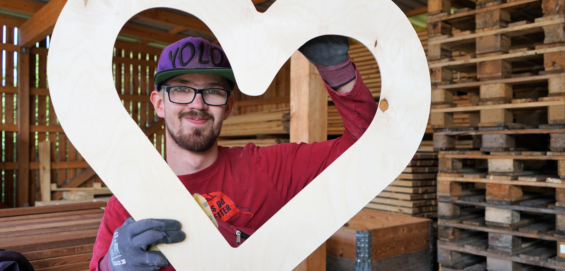 Mann hält selbstgemachtes Holzherz